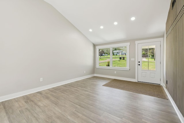 entrance foyer with recessed lighting, light wood-style flooring, baseboards, and vaulted ceiling