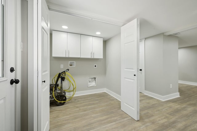 laundry room featuring hookup for a washing machine, light wood-type flooring, hookup for an electric dryer, baseboards, and cabinet space