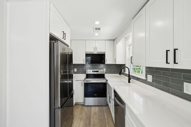 kitchen with visible vents, white cabinetry, a sink, and appliances with stainless steel finishes