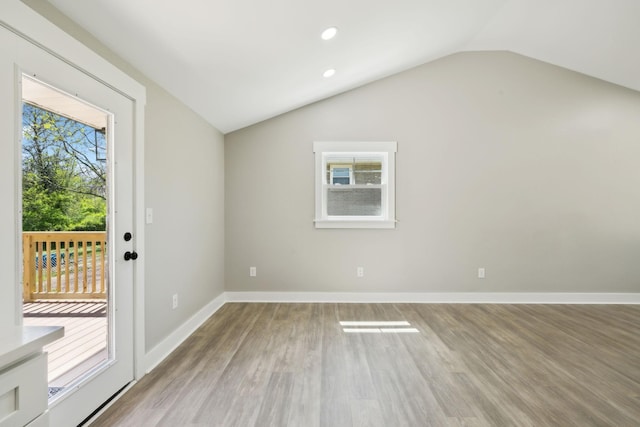 interior space featuring recessed lighting, light wood-type flooring, baseboards, and lofted ceiling