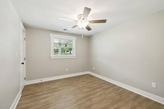 unfurnished room featuring wood finished floors, baseboards, a ceiling fan, and visible vents