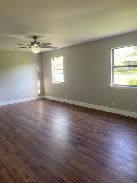unfurnished room featuring dark wood-style flooring, baseboards, and a ceiling fan