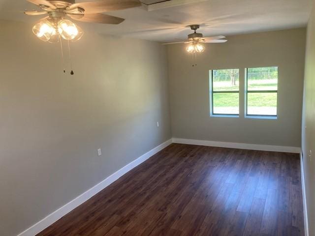 unfurnished room featuring dark wood-style floors, baseboards, and ceiling fan