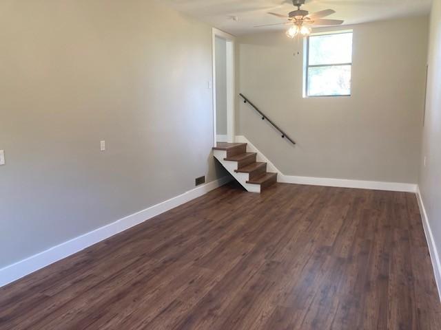 interior space featuring dark wood finished floors, baseboards, and a ceiling fan