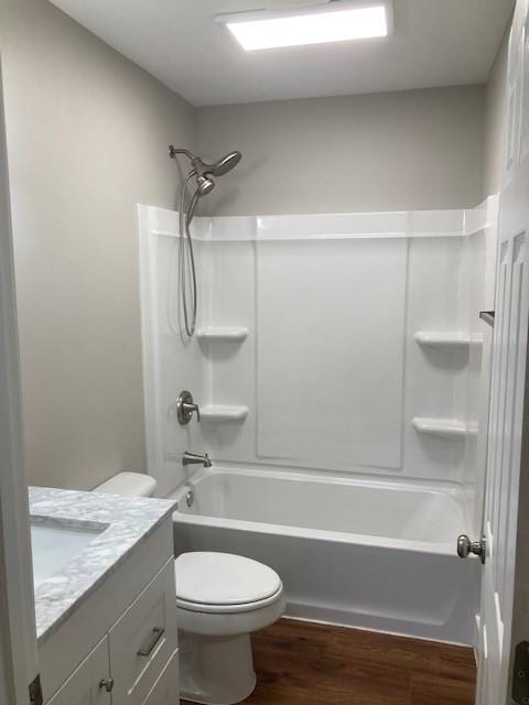 full bathroom featuring washtub / shower combination, toilet, vanity, and wood finished floors