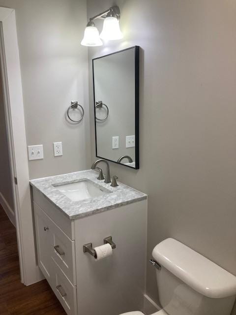 bathroom with vanity, toilet, and wood finished floors