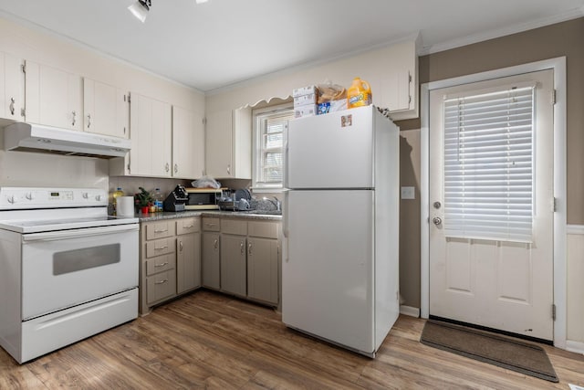 kitchen with white cabinets, white appliances, under cabinet range hood, crown molding, and wood finished floors