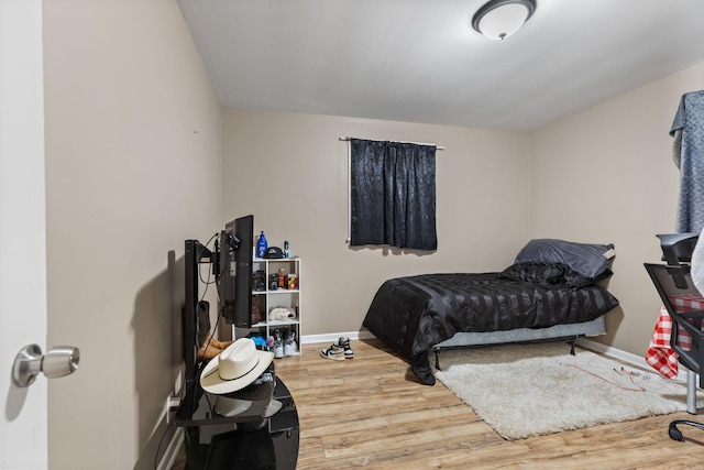 bedroom with baseboards and wood finished floors