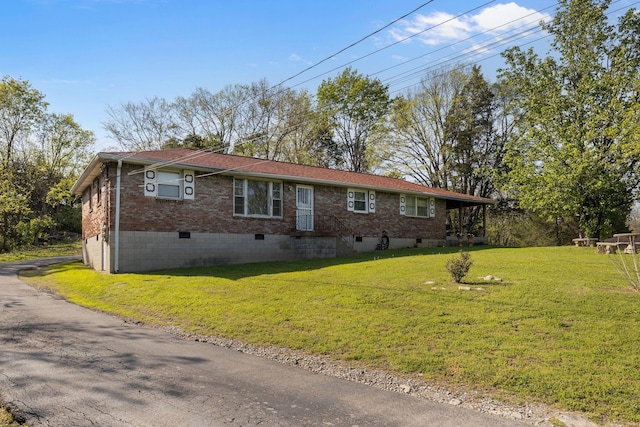 view of front of home with a front yard, brick siding, and crawl space
