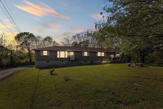 view of front of property featuring crawl space, aphalt driveway, a front yard, and brick siding