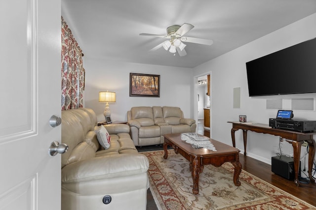 living room featuring baseboards, wood finished floors, and ceiling fan