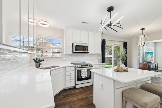 245 Wisteria Dr, Franklin, TN 37064 - kitchen featuring dark wood finished floors, stainless steel electric range oven, a kitchen island, a sink, and backsplash
