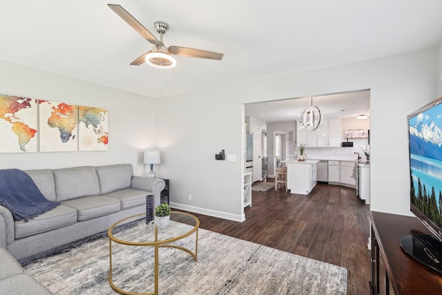 245 Wisteria Dr, Franklin, TN 37064 - living area featuring ceiling fan with notable chandelier, baseboards, and dark wood-style floors