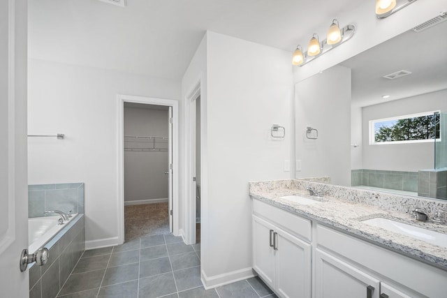bathroom with tile patterned floors, a sink, a spacious closet, and visible vents
