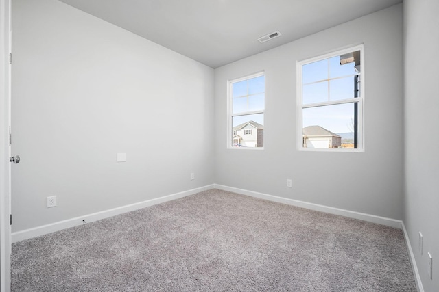 spare room with visible vents, baseboards, and carpet floors