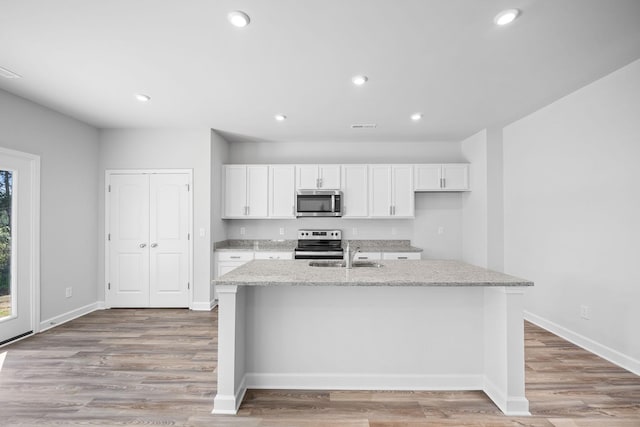 kitchen with a sink, white cabinets, appliances with stainless steel finishes, and recessed lighting
