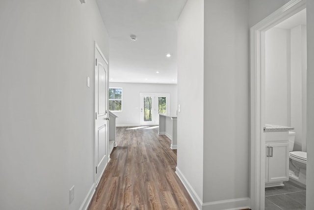 hallway featuring recessed lighting, dark wood-type flooring, and baseboards