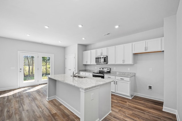 kitchen featuring baseboards, white cabinets, visible vents, stainless steel appliances, and a sink