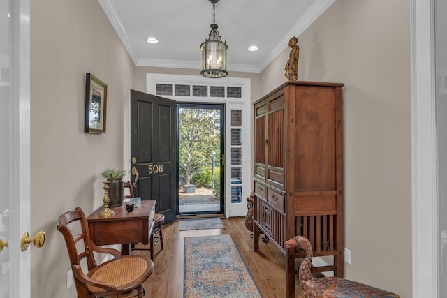 foyer entrance with ornamental molding, recessed lighting, and wood finished floors
