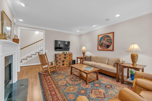 living room with wood finished floors, recessed lighting, a high end fireplace, and stairs