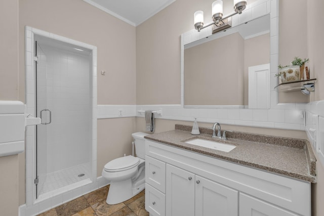 full bath with toilet, crown molding, a shower stall, vanity, and a wainscoted wall