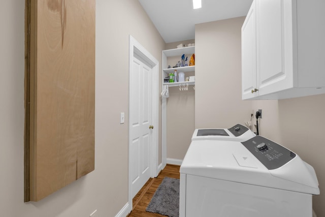 washroom featuring washer and dryer, wood finished floors, baseboards, and cabinet space