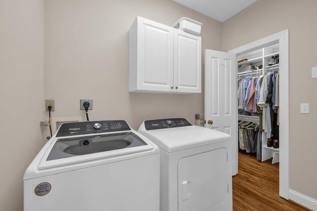 laundry room featuring cabinet space, baseboards, washer and dryer, and wood finished floors