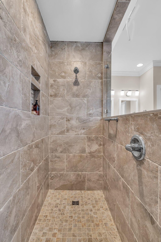 bathroom with tiled shower and ornamental molding