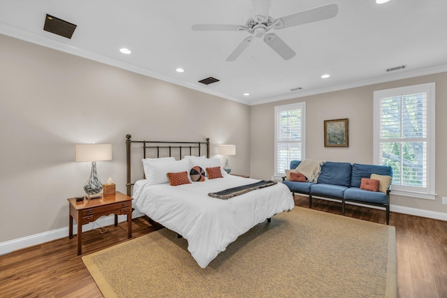 bedroom with visible vents, crown molding, and wood finished floors
