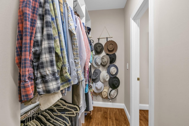walk in closet with wood finished floors
