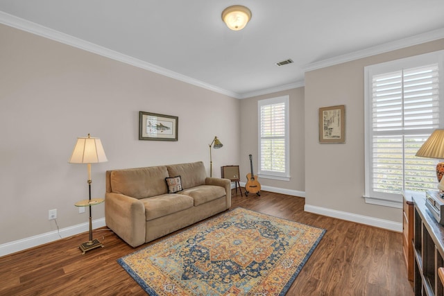 living area featuring crown molding, wood finished floors, baseboards, and visible vents