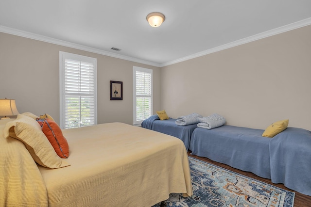 bedroom featuring crown molding, wood finished floors, and visible vents