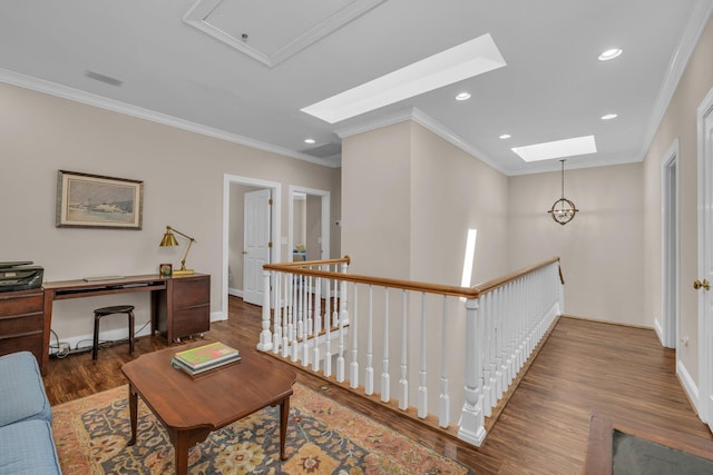 hallway featuring crown molding, wood finished floors, an upstairs landing, and a skylight