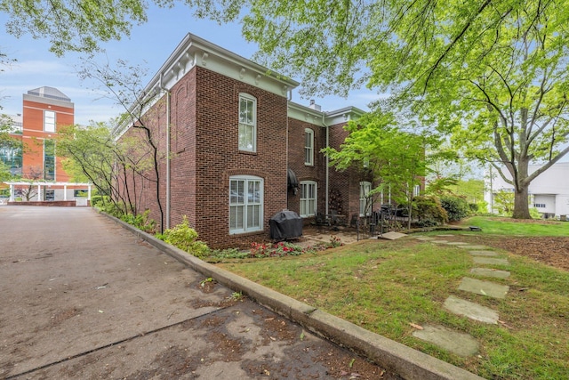 exterior space featuring a yard and brick siding