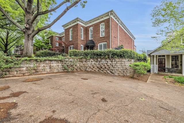 view of property exterior with a patio area and brick siding