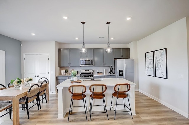 5046 Lawler Ln, Old Hickory, TN 37138 - kitchen with light countertops, a kitchen island with sink, appliances with stainless steel finishes, and a sink