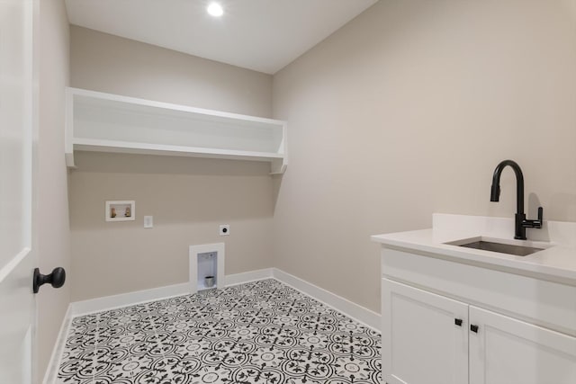 washroom with baseboards, a sink, cabinet space, electric dryer hookup, and hookup for a washing machine