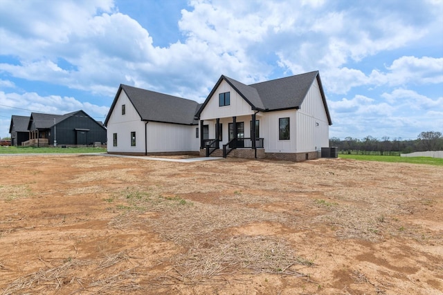modern farmhouse style home featuring a porch, central AC, and board and batten siding