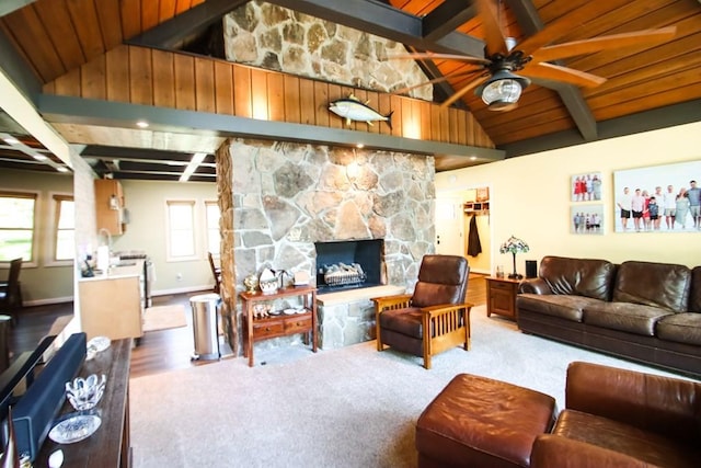 living room with a ceiling fan, a stone fireplace, wooden ceiling, baseboards, and beam ceiling