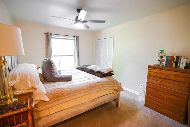 carpeted bedroom featuring a closet, baseboards, and a ceiling fan