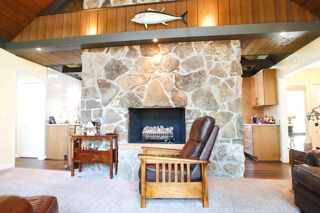 sitting room with carpet floors, a fireplace, vaulted ceiling, and wood ceiling