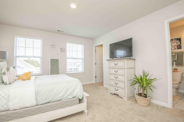 bedroom featuring light carpet, ensuite bathroom, baseboards, and visible vents