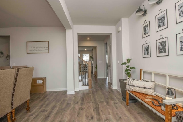 corridor featuring baseboards, recessed lighting, wood finished floors, and stairs