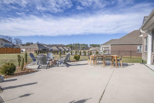 view of patio / terrace with fence, a fire pit, a residential view, and outdoor dining area