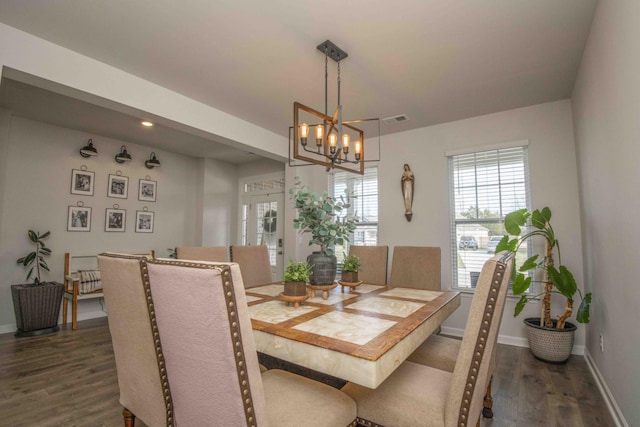 dining room with dark wood-type flooring, visible vents, a wealth of natural light, and a chandelier