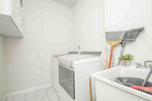 laundry area with baseboards, a sink, cabinet space, washer and clothes dryer, and marble finish floor