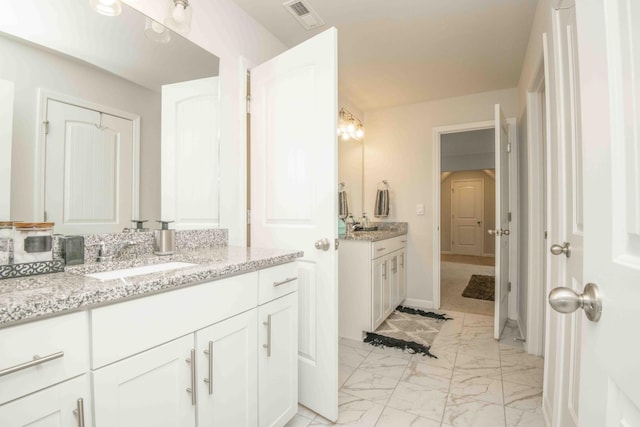full bath with visible vents, baseboards, a sink, two vanities, and marble finish floor