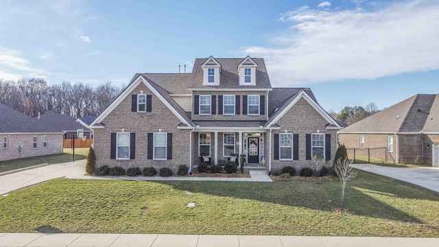 view of front of property featuring a front yard, fence, and brick siding