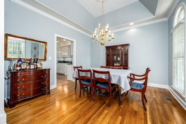 dining space featuring a chandelier, wood finished floors, visible vents, and plenty of natural light