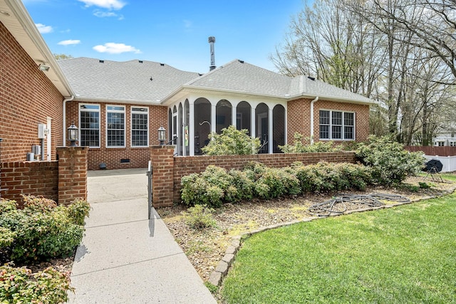 view of front of property with brick siding, a front yard, a porch, and roof with shingles